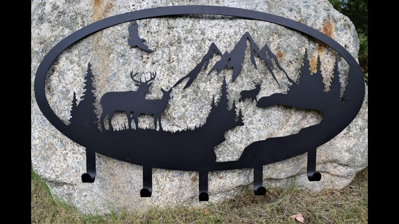 custom black metal coat rack featuring 3 deer, eagle, mountain's and trees with 5 hooks. 36 inches wide by 21 inches high priced at 180.00 dollars. SKU number CD18X36