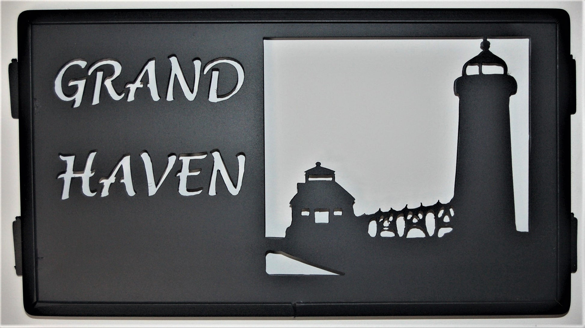 black metal Grand Haven inspiring panel featuring lighthouse, bridge and house