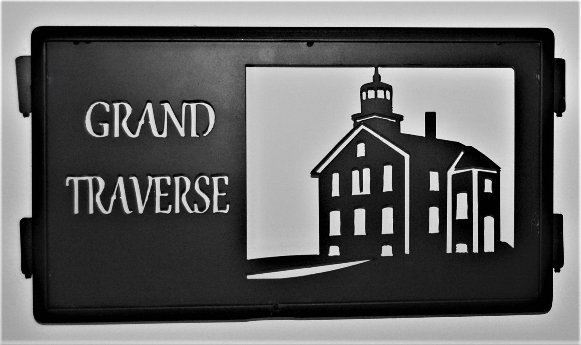 black metal grand traverse inspiring panel featuring lighthouse 